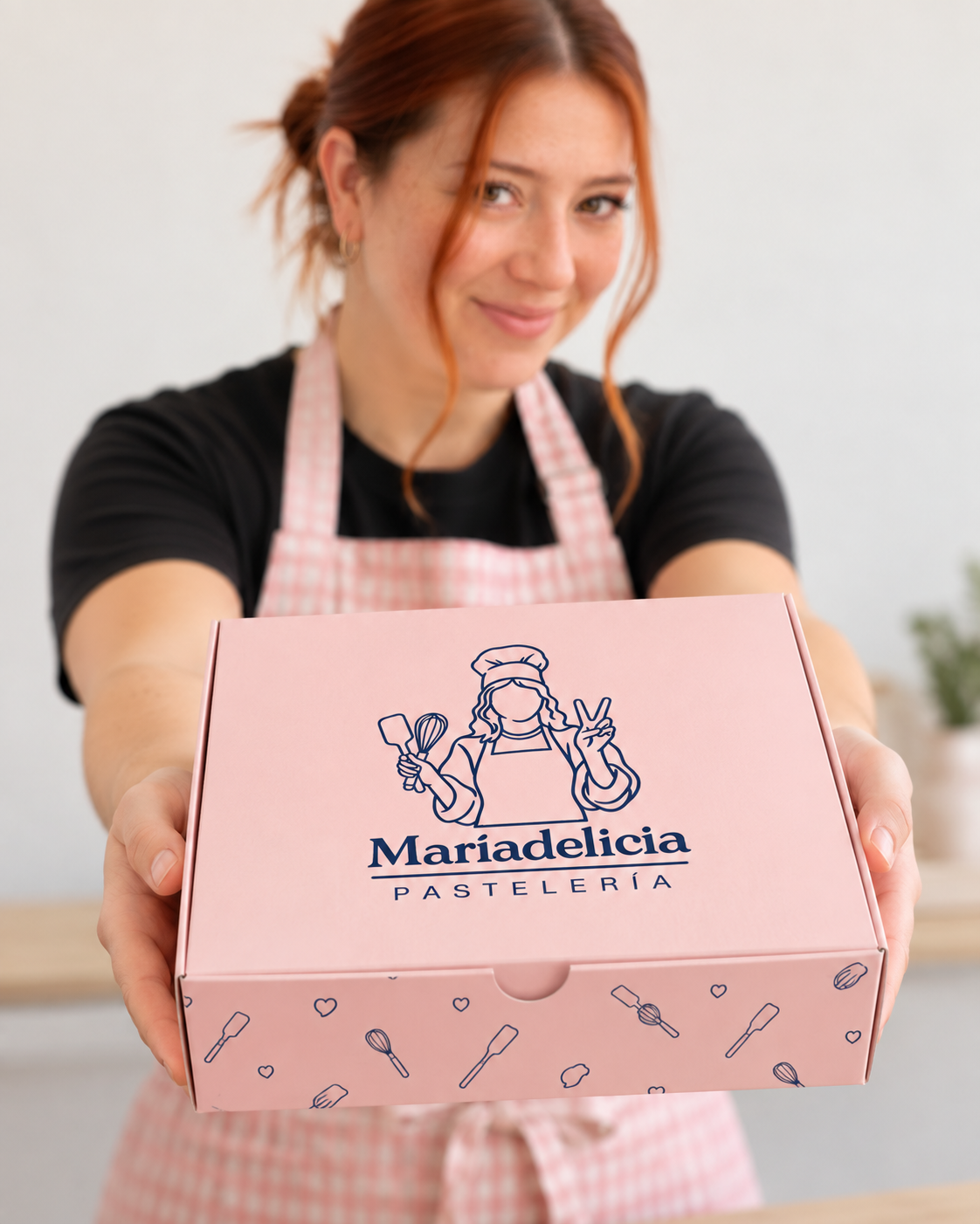 Ángela entregando una caja rosada de Maríadelicia