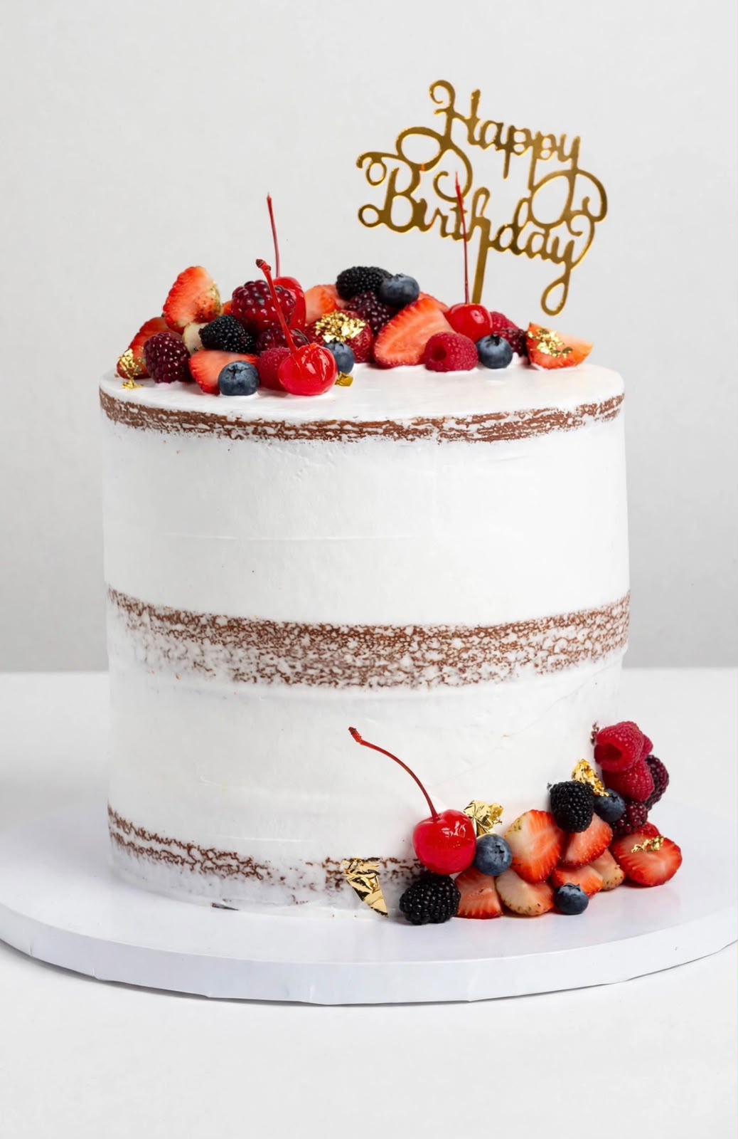 Pastel estilo naked cake con crema blanca y frutos rojos frescos encima